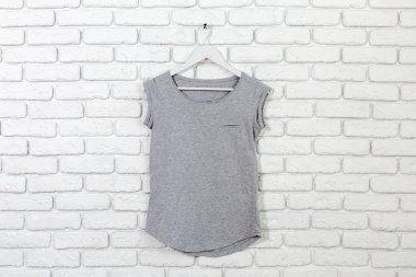 t-shirt ile tuğla badanalı duvara askı