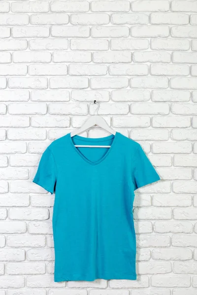 brick whitewashed wall with t-shirt on hanger