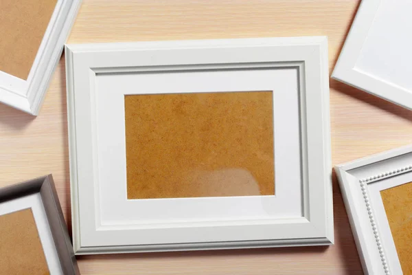 Different empty photo frames on table