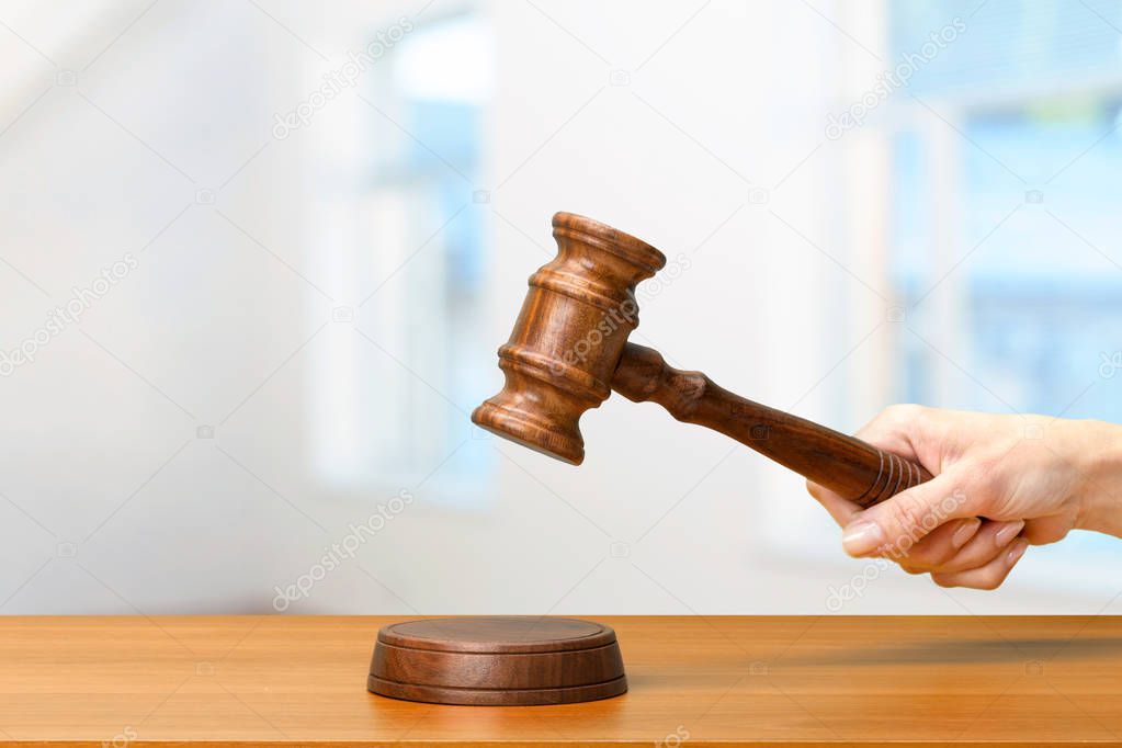 someones hand holding Wooden Law Gavel