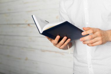 Adam okuma kitabı onun elinde.