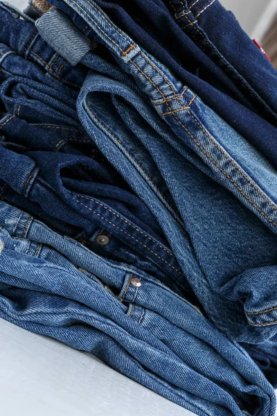 Pile of blue casual jeans, close-up