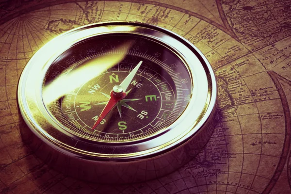 Close up old vintage compass on ancient map