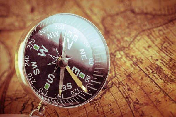 Close up old vintage compass on ancient map