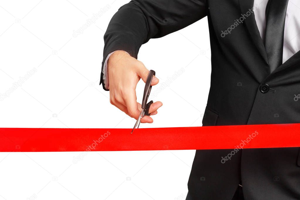 businessman with Scissors cutting red ribbon or tape. Isolated on white background.