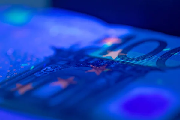 close up of checking money under ultraviolet lamp