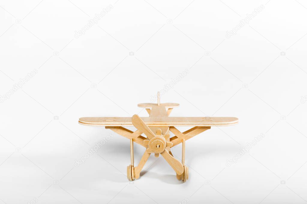 close up of wooden toy airplane isolated on light background 