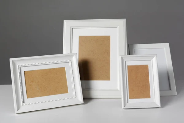 Different empty photo frames on table