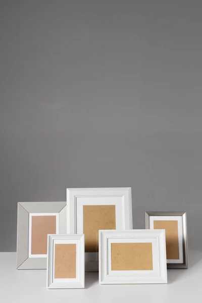 Different empty photo frames on table
