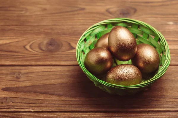 Χρυσά Πασχαλινά Αυγά Στο Ξύλινο Τραπέζι — Φωτογραφία Αρχείου