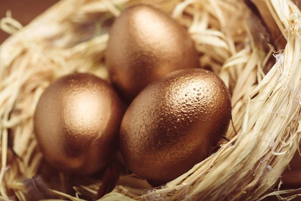 Χρυσά Πασχαλινά Αυγά Στο Ξύλινο Τραπέζι — Φωτογραφία Αρχείου