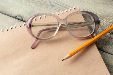 Not defteri ve gözlük masaya yakın çekim