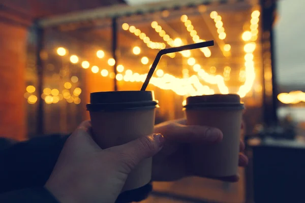 Young friends drinking coffee in paper take away cup