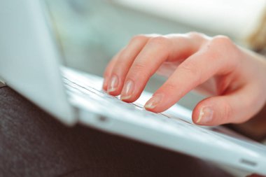 Genç kadın kullanarak dizüstü bilgisayar yakın çekim