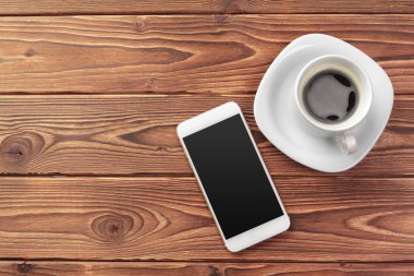Mobil akıllı telefon ve bir fincan kahve ahşap arka plan doku