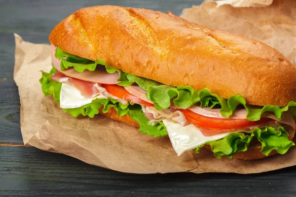 Nahaufnahme Von Leckeren Sandwiches Auf Papier Und Einem Holztisch — Stockfoto
