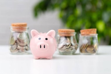 Masanın üzerinde bozuk paralar olan kumbara.