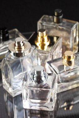 Karanlık bir arka planda parfüm şişeleri