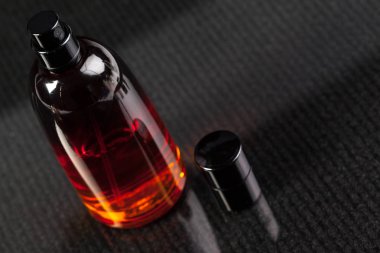 Karanlık bir arka planda parfüm şişesi