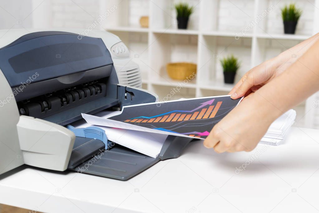 close up of person using modern printer in office