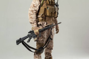 Kamuflajlı asker elinde tüfekle