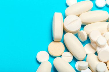 Mavi bir arka plan üzerinde hap saçılmış