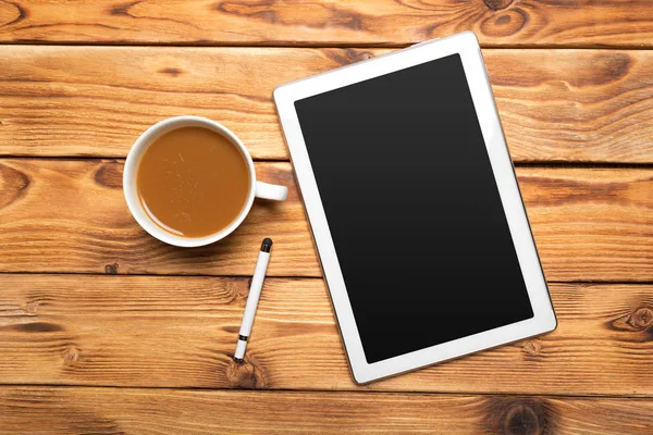 digital tablet and coffee cup on wooden table