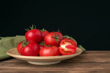 siyah arka plan üzerine bir tabak içinde domates