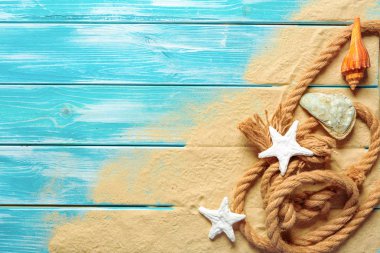 deniz mavi ahşap arka plan üzerinde kum üzerinde deniz kabukları ile deniz ip. Üstten görünüm