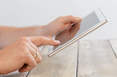 tablet cihaz ahşap çalışma masa üzerinde tutan bir adam elinde