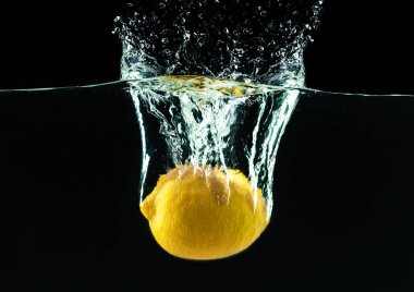 su sıçrama siyah arka plan üzerine taze sarı limon