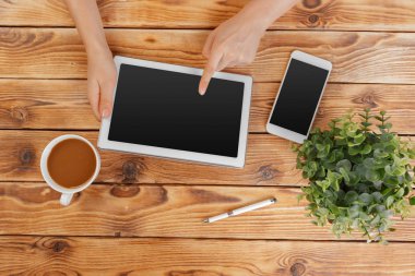 Dijital tablet ve ahşap bir masa üzerinde kahve ile kız el