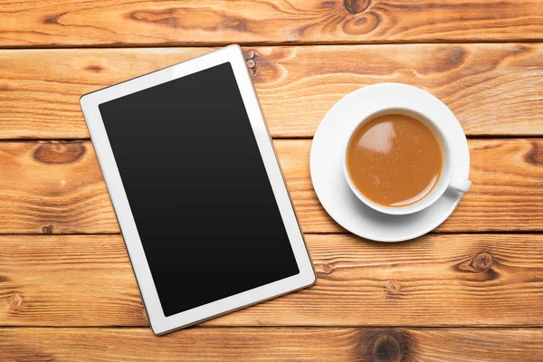 デジタル タブレットと木製のテーブルでコーヒー カップ — ストック写真