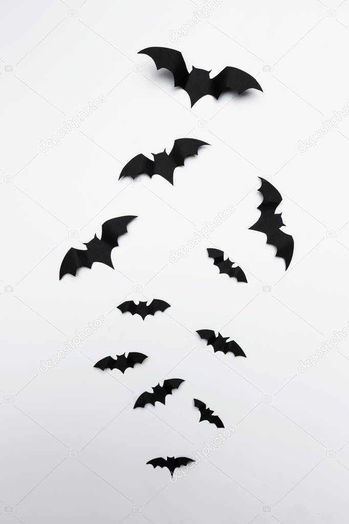 halloween and decoration concept - flying paper bats 