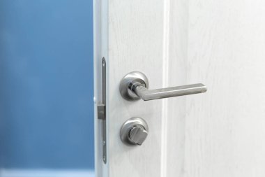 Beyaz kapı yatay bir metalik düğme ayrıntısı