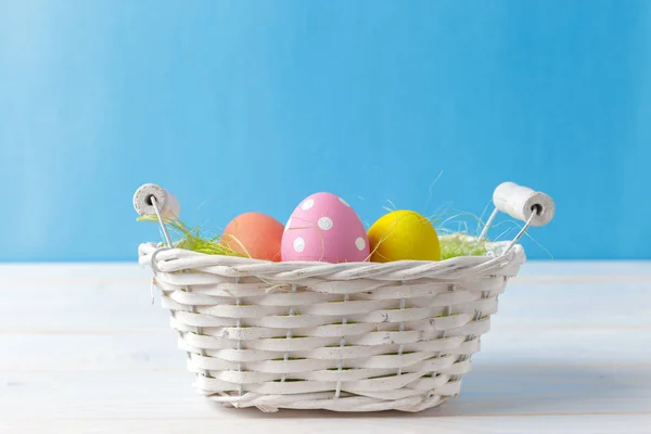バスケットにカラフルな卵のイースター休日の背景 — ストック写真