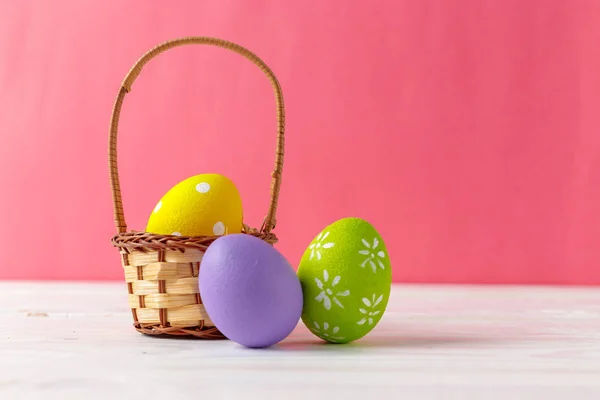 バスケットにカラフルな卵のイースター休日の背景 — ストック写真