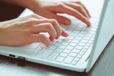 Genç kadın kullanarak dizüstü bilgisayar yakın çekim