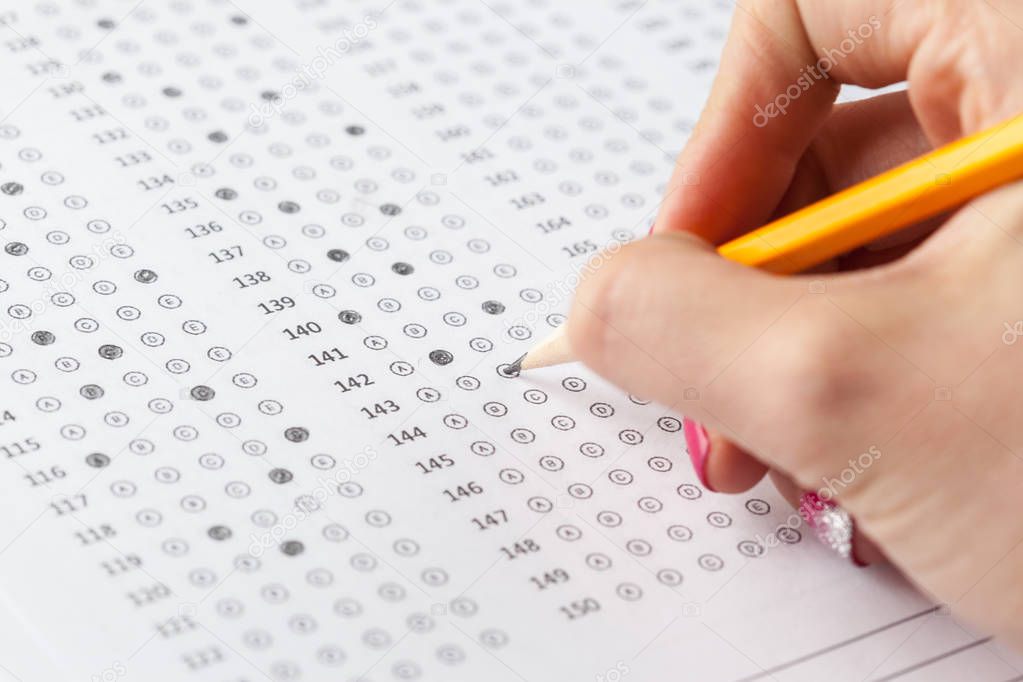 close up of person filling Test score sheet with answers