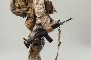 Kamuflajlı asker elinde tüfekle