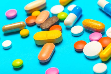 Mavi bir arka plan üzerinde hap saçılmış