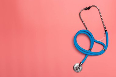 Pembe bir arka plan üzerinde üstten görünüm, stetoskop. Yat ve uzay kopyalayın. Tıp kavramı.