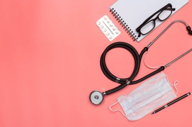 pastel pembe bir arka plan üzerinde tıbbi ekipman üstten görünüm.