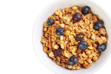 Beyaz arka plan üzerinde izole meyve parçaları ile ev yapımı granola kase