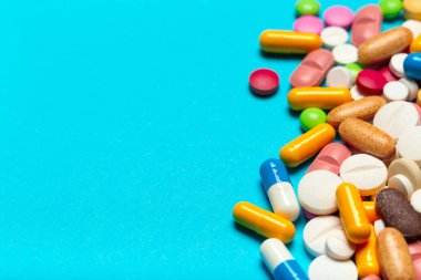 Mavi bir arka plan üzerinde hap saçılmış