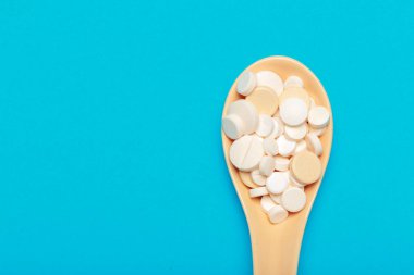 Mavi bir arka plan üzerinde hap saçılmış