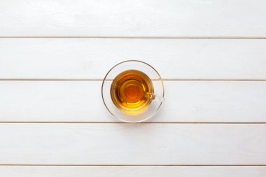 Beyaz ahşap masada bir fincan çay