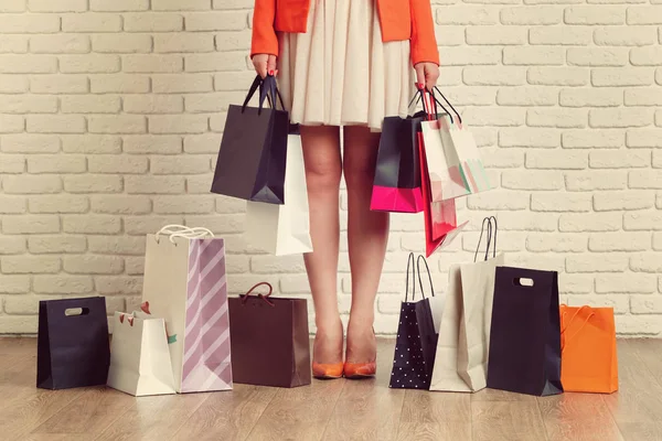 カラフルなショッピング バッグを持って若い女性の脚のショットを閉じる — ストック写真