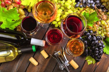 Beyaz üzüm dalları ile şarap. Ahşap bir masaya.