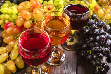 Beyaz üzüm dalları ile şarap. Ahşap bir masaya.